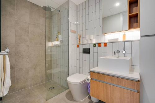 y baño con ducha, aseo y lavamanos. en Bright 2B apt next to Flagstaff Garden freeparking#FG1003, en Melbourne