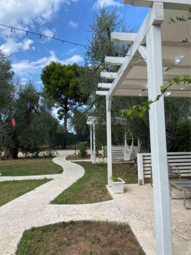 a white pergola next to a walkway at Residence Alba in Vieste