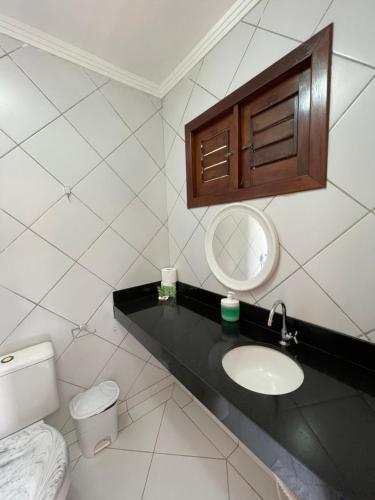 a bathroom with a sink and a toilet and a mirror at Praia das Tartarugas in Barra de Tabatinga