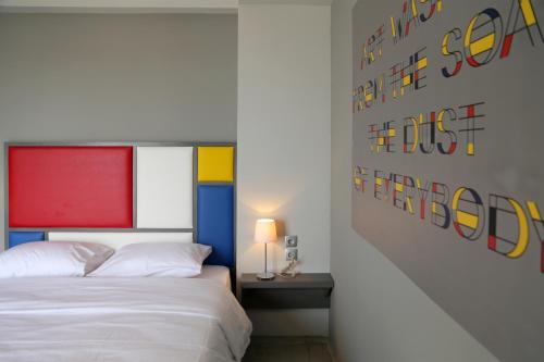 a bedroom with two beds and a wall with colorful art at Design Architectonika in Skiathos Town