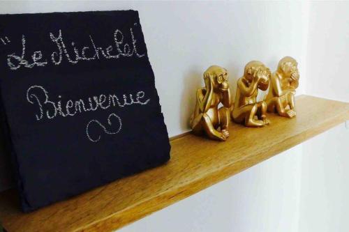 a group of gold figurines sitting on a wooden shelf at « Le Michelet »un cocon en ville in Saint-Étienne