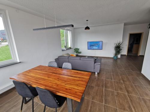 a living room with a wooden table and a couch at Ferienwohnung mit Garten und terasse Münsingen in Münsingen