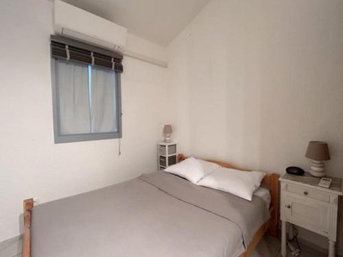 - une chambre blanche avec un lit et une fenêtre dans l'établissement Maisonnette, résidence au calme avec terrasse et parking privé 4AM21, au Barcarès