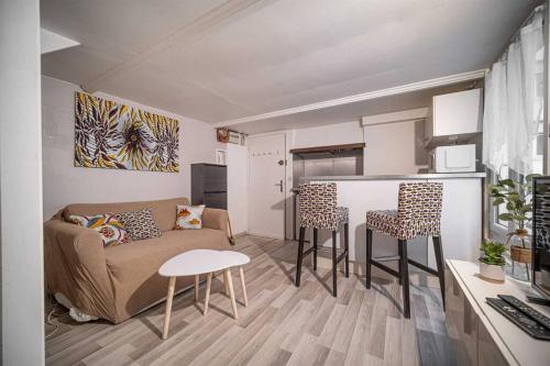 un salon avec un canapé, une table et des chaises dans l'établissement Charmant DUPLEX - centre de Fontainebleau, à Fontainebleau