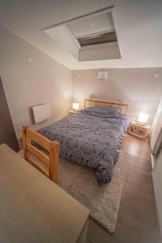 - une chambre avec un lit et une table avec deux lampes dans l'établissement Charmant DUPLEX - centre de Fontainebleau, à Fontainebleau