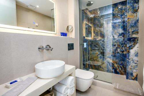 y baño con lavabo y ducha. en euphoria boutique hotel, en Chrysi Ammoudia