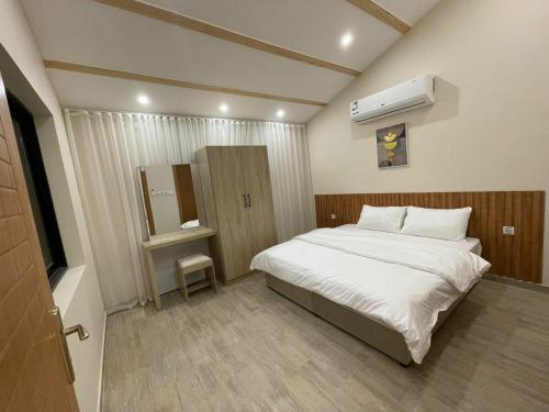 a small bedroom with a bed and a air conditioner at شاليهات النرجس in Obhor