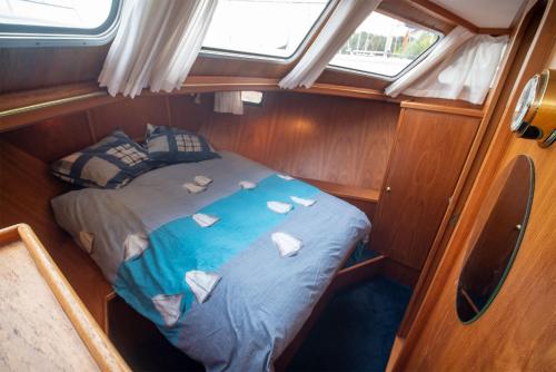 Habitación pequeña con cama en medio de un barco en Vedette Hollandaise de 13 m pour séjour insolite, en Nivillac