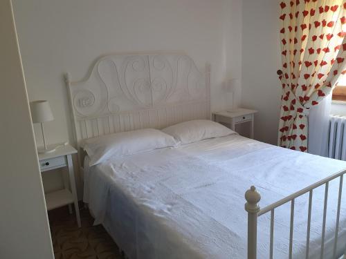 a bedroom with a white bed and two night stands at B&B Da Nonna Lucia in Roccascalegna