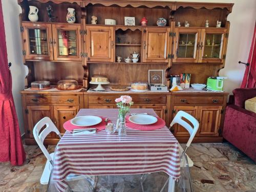 a kitchen with a table with plates and flowers on it at B&B Da Nonna Lucia in Roccascalegna