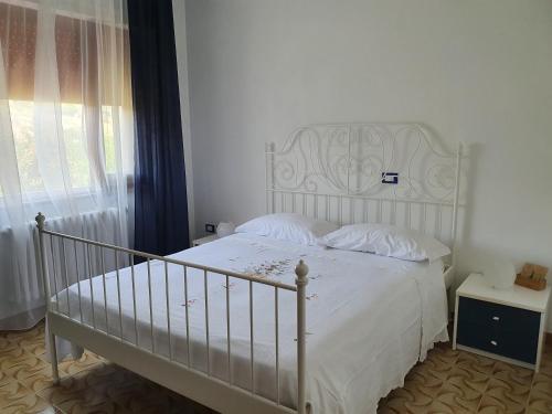 a bedroom with a white bed and a window at B&B Da Nonna Lucia in Roccascalegna