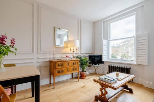 a living room with a table and a mirror at Luxury flat on Fulham/Chelsea border in London