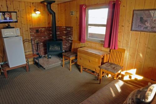 a living room with a fireplace and a stove at Lazy R Cottages- 1 apts in Estes Park
