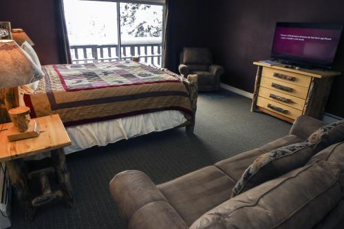 een woonkamer met een bed, een bank en een tv bij Fawn Valley Inn- 304 condo in Estes Park