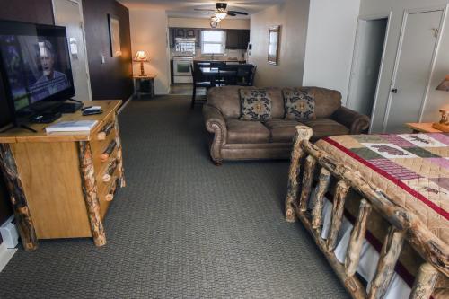 een woonkamer met een bed, een bank en een televisie bij Fawn Valley Inn- 304 condo in Estes Park