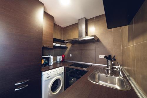 una pequeña cocina con fregadero y lavavajillas en Vistalegre Apartments6, en Madrid