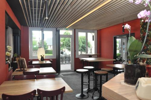 un restaurant avec des tables, des chaises et des fenêtres dans l'établissement Hôtel des Voyageurs Restaurant Traiteur, à Bagnols