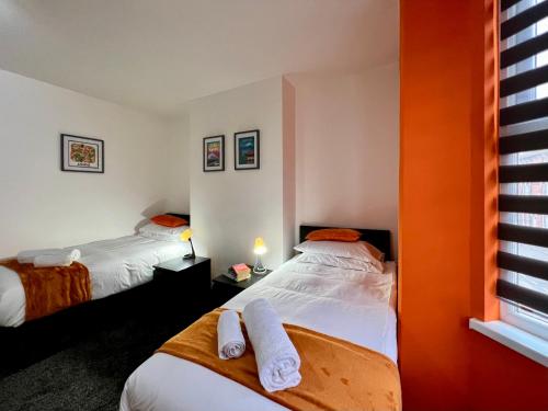 a bedroom with two beds with towels on them at St Michael's House - Great for Contractors or Family Holidays in Nottingham