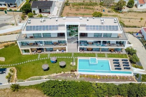 an aerial view of a large building with a swimming pool at Ericeira Surf Apartments in Ericeira