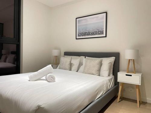 a bedroom with a bed with white sheets and pillows at Classy 2B apt next to Albert Park w Free Parking#LA09 in Melbourne
