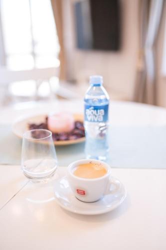 a cup of coffee and a bottle of water on a table at Slavija Fontana Lux Apartments in Belgrade