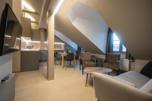 a living room with a couch and a table and chairs at APARTAMENTAI LEMBERGAS in Vilnius