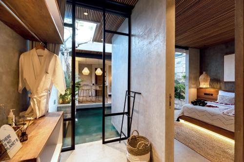 a bedroom with a bed and a sink and a mirror at Danu Villas Bali in Kerobokan