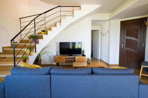een woonkamer met een blauwe bank en een trap bij Villa Arianna, il piacere di vivere nella natura. in Alcamo