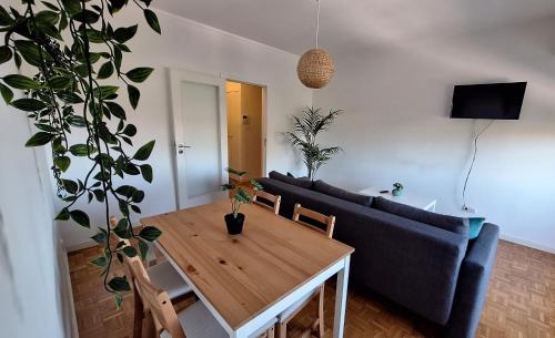 ein Wohnzimmer mit einem Tisch und einem Sofa in der Unterkunft Apartamentos Jardim do Morro in Vila Nova de Gaia
