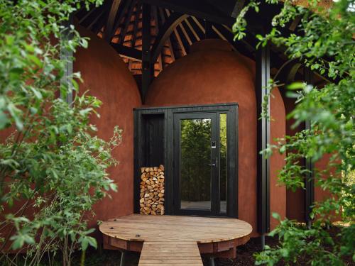 a front door of a house with a wooden bench at Maidla Nature Resort in Maidla