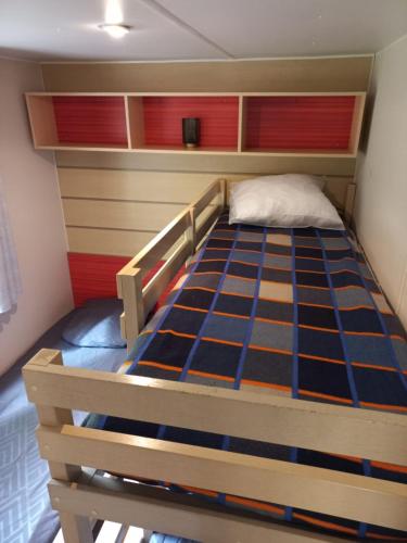 - un lit dans une petite chambre avec un cadre de lit dans l'établissement Mobil-House 2 chambres Saint-Chéron, à Saint-Chéron