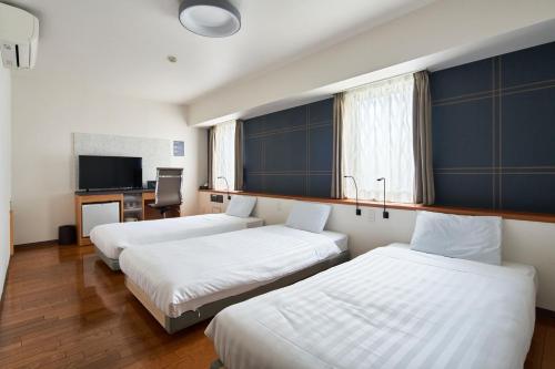 Habitación de hotel con 3 camas y TV en TOKIO's HOTEL, en Tokio