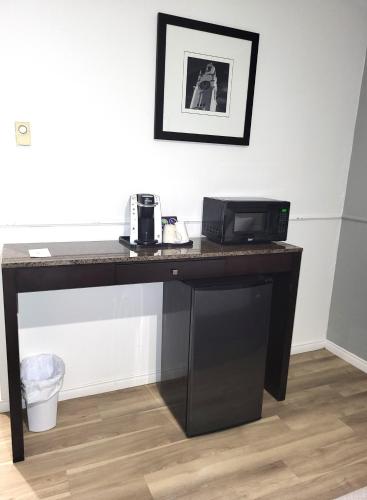 a black desk with a microwave on top of it at Hotel Sigma in Val-dʼOr