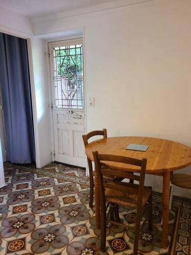 une salle à manger avec une table et des chaises en bois dans l'établissement Les Bambous - Rez de jardin Millau Centre - Parking privatif, wifi, à Millau