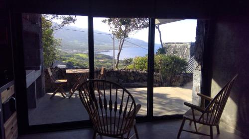 a room with two chairs and a balcony with a view at Lava Homes in Santo Amaro