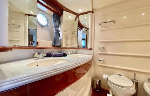 een badkamer met een wastafel, een toilet en een spiegel bij luxerholiday in Antalya