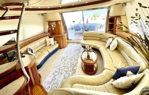 a room with couches and a table in a boat at luxerholiday in Antalya