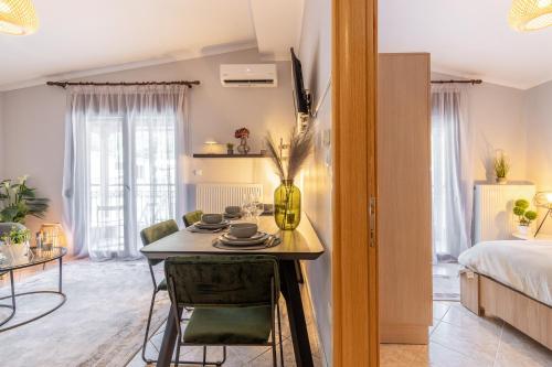 a room with a table and chairs and a bed at Luxury Central Apartment in Xanthi