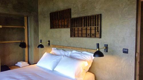 a bedroom with a bed with two lights on the wall at Lava Homes in Santo Amaro