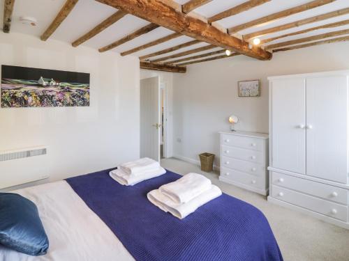 a bedroom with a bed with two towels on it at Chapel Cottage in Pershore