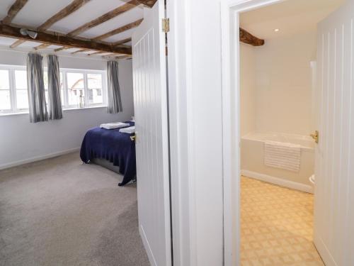 a bedroom with a bed and a tub in a room at Chapel Cottage in Pershore