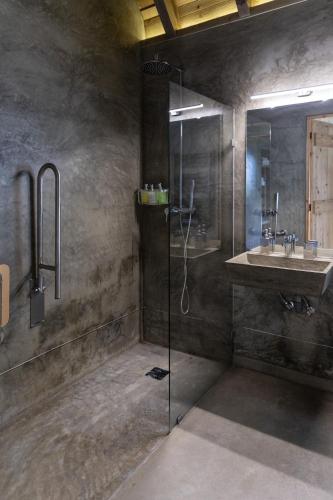 a bathroom with a glass shower and a sink at Lava Homes in Santo Amaro