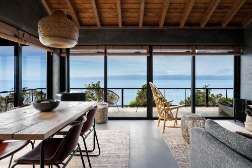 a dining room with a table and a view of the ocean at Lava Homes in Santo Amaro