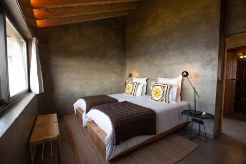a bedroom with a large bed with white sheets and pillows at Lava Homes in Santo Amaro