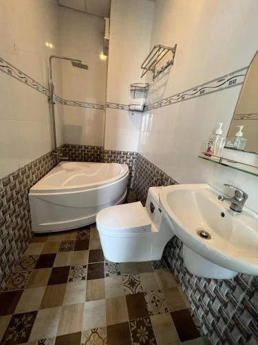 a bathroom with a tub and a toilet and a sink at Sky View Hotel in Can Tho