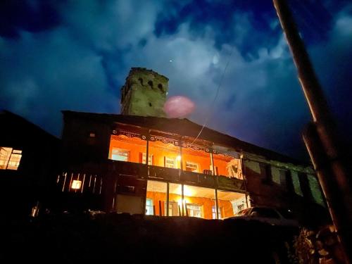 a building with a clock tower on top of it at night at Old House in Adishi