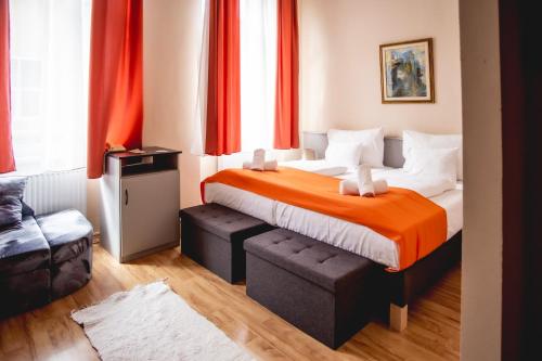 a bedroom with a large bed with red curtains at Hotel Kapos in Kaposvár