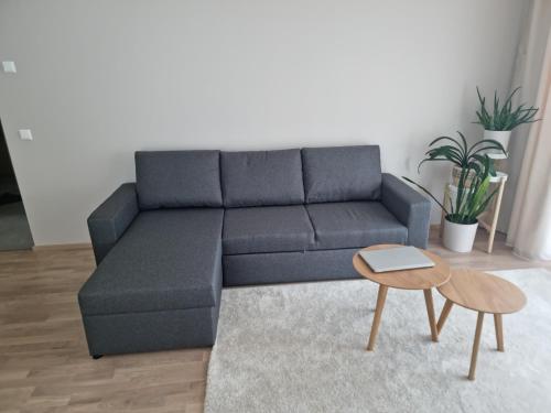 a blue couch in a living room with a table at 7th floor Tallinn in Iru