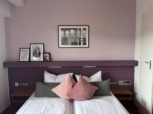 a bedroom with a bed with pink and grey pillows at Haus am Wald in Eltmann