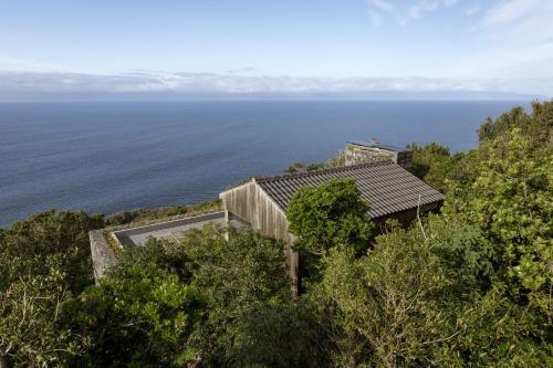 an aerial view of a house on a hill overlooking the ocean at Lava Homes in Santo Amaro